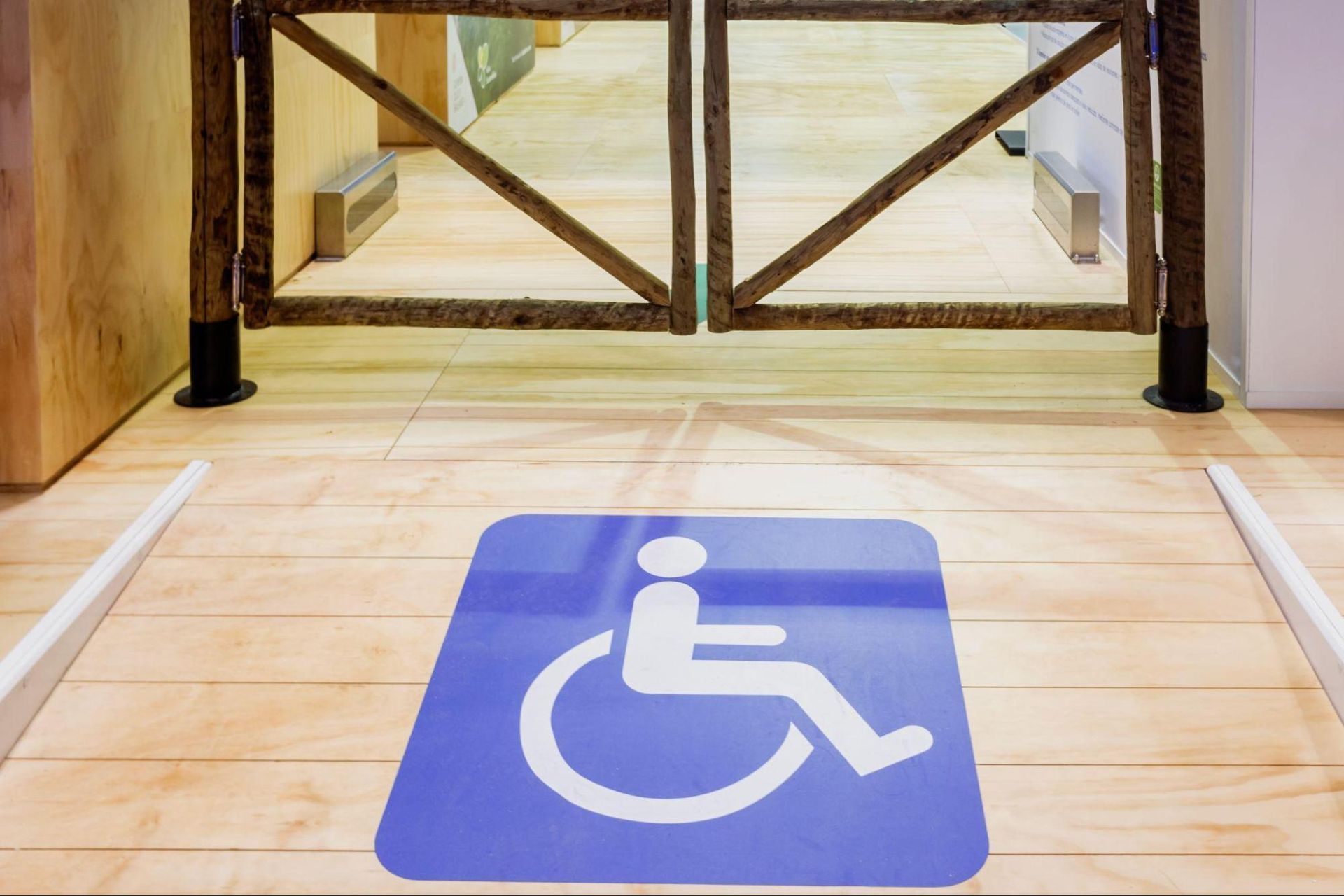 Wooden gate obstructing a marked accessible route at a commercial entrance