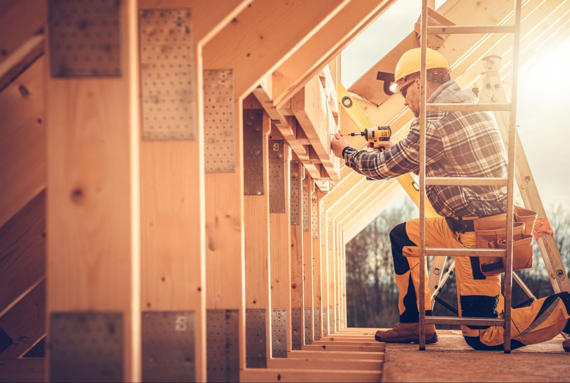 Contractor using a drill on timber framing