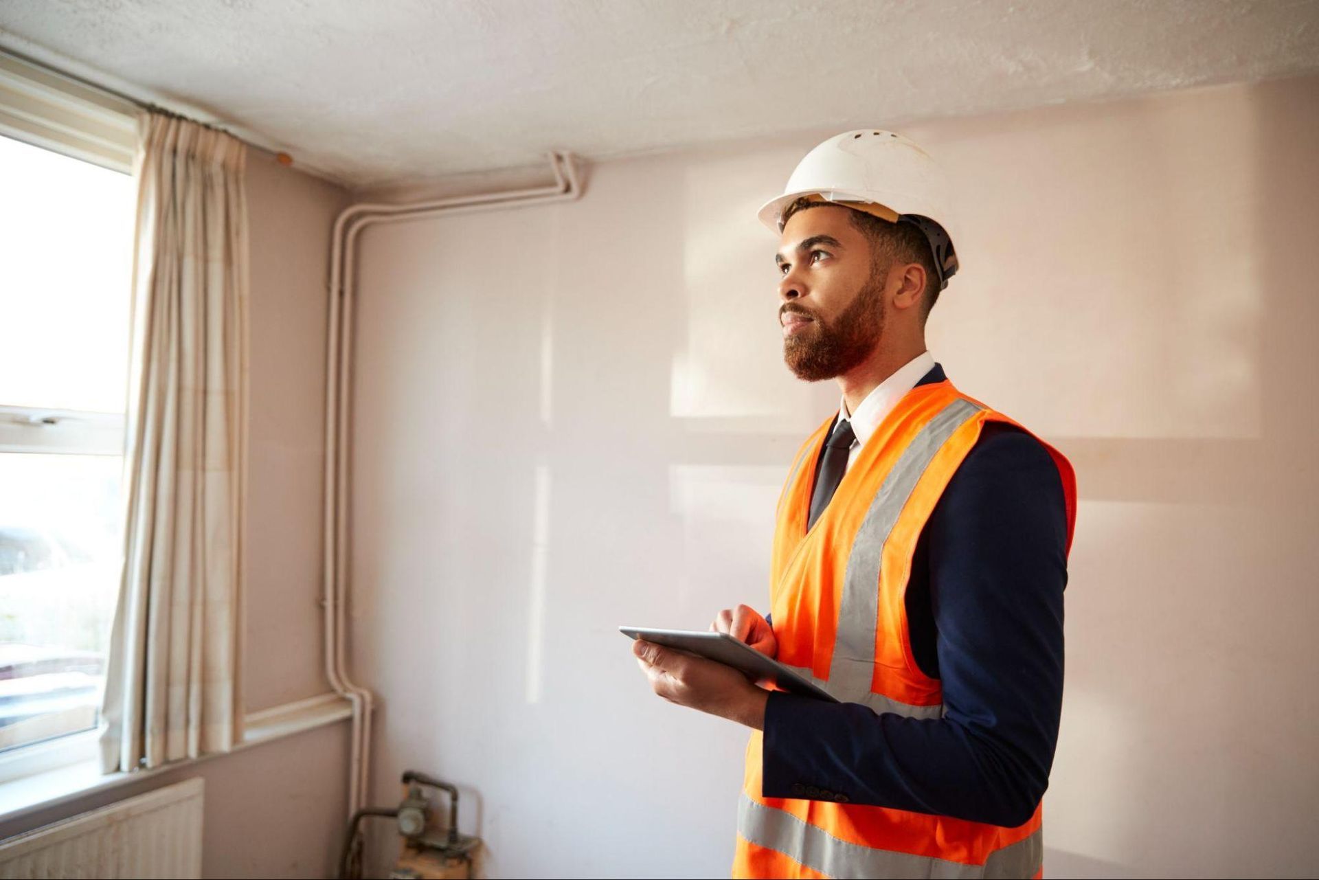 Home Inspection Fall Creek professional inspecting a home interior while reviewing property details on a tablet.