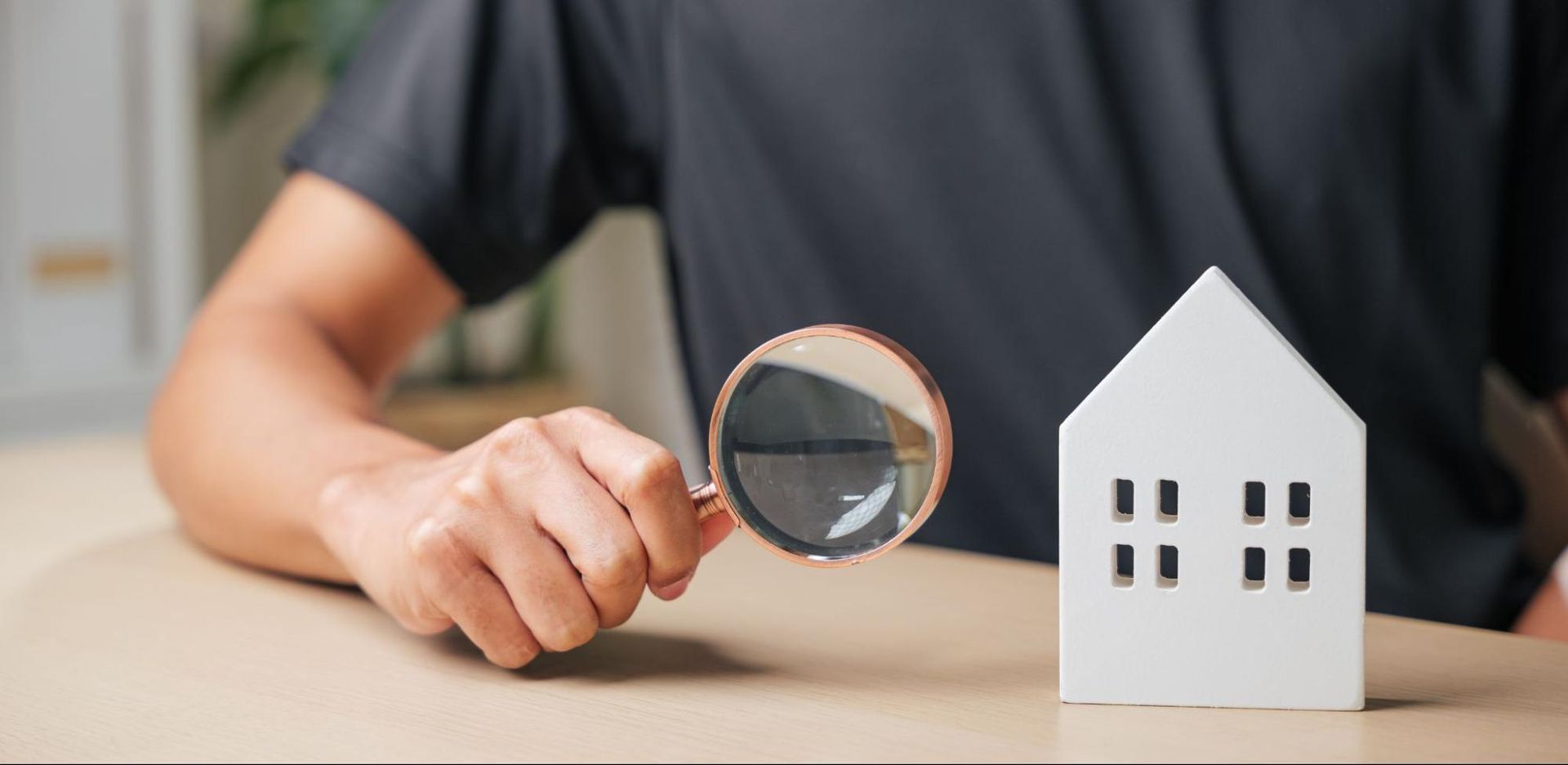 miniature house and magnifying glass, symbolizing a home inspection in Conroe
