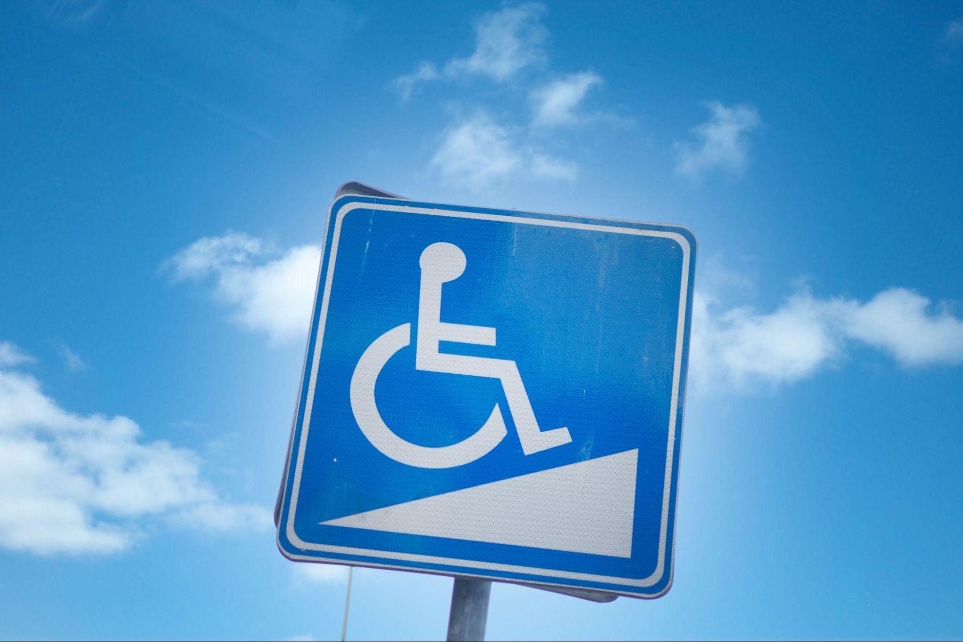 Accessible parking sign with wheelchair symbol representing TAS/ADA inspection