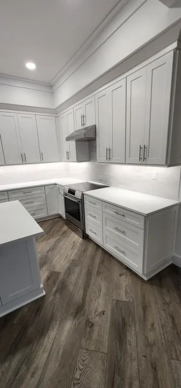 Bright white modern kitchen with gray cabinets, quartz counters, and wood-look flooring