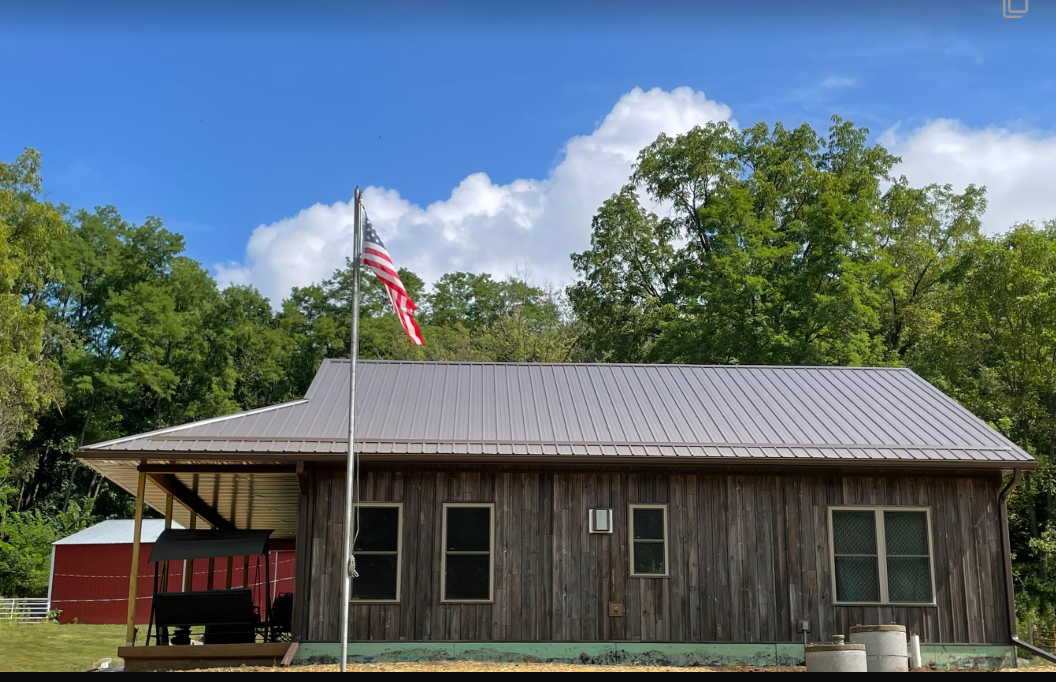 A large wooden house with a flag flying in front of it.
