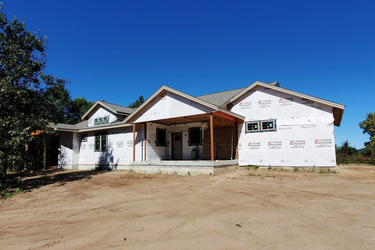 A house is being built in the middle of a dirt field.