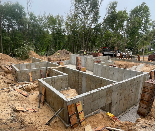 The foundation of a house is being built in the dirt.