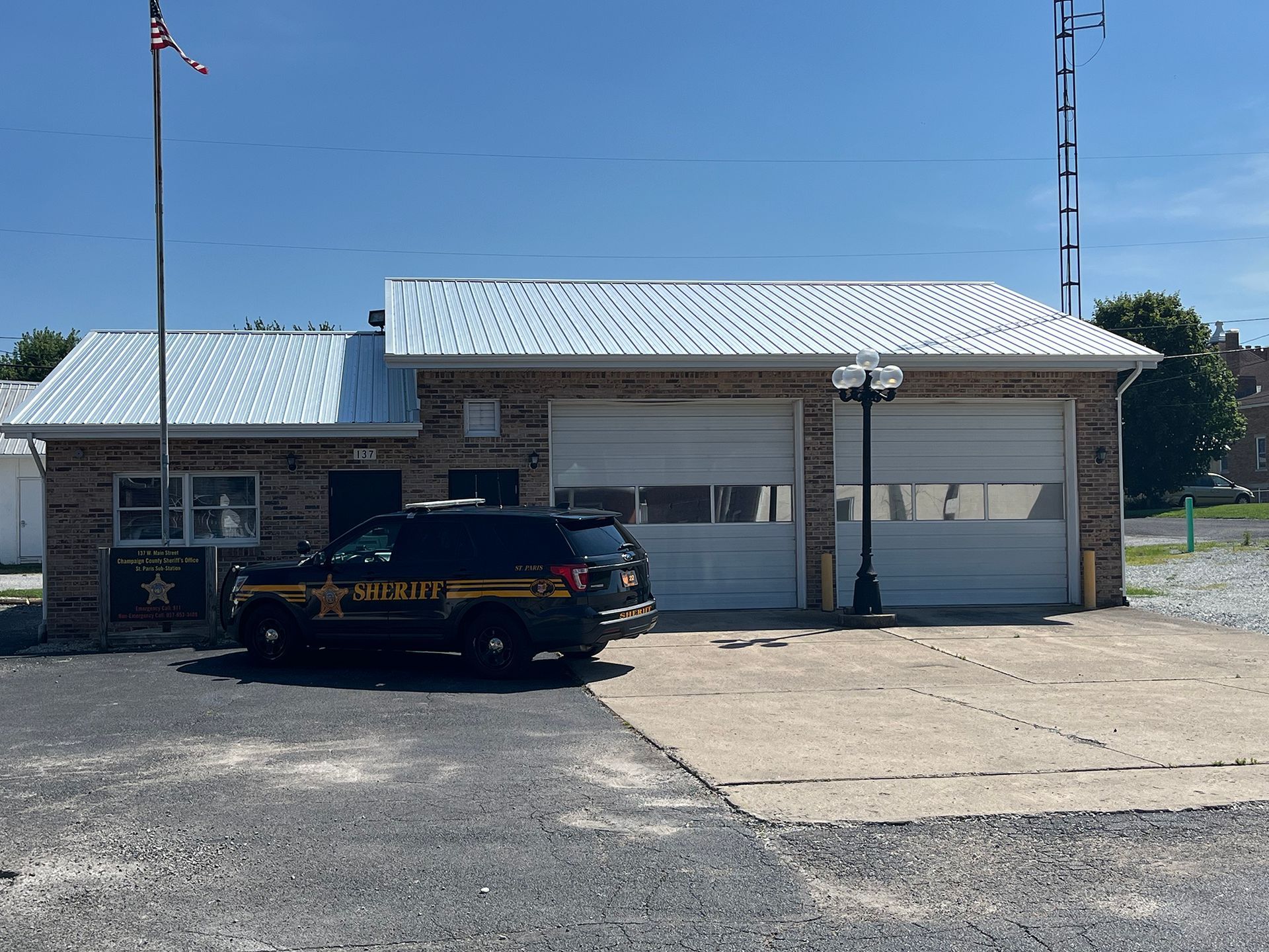 Sheriff's office building with a black and yellow police SUV parked in front.