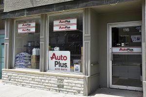 Auto Plus auto parts store storefront with a window display.