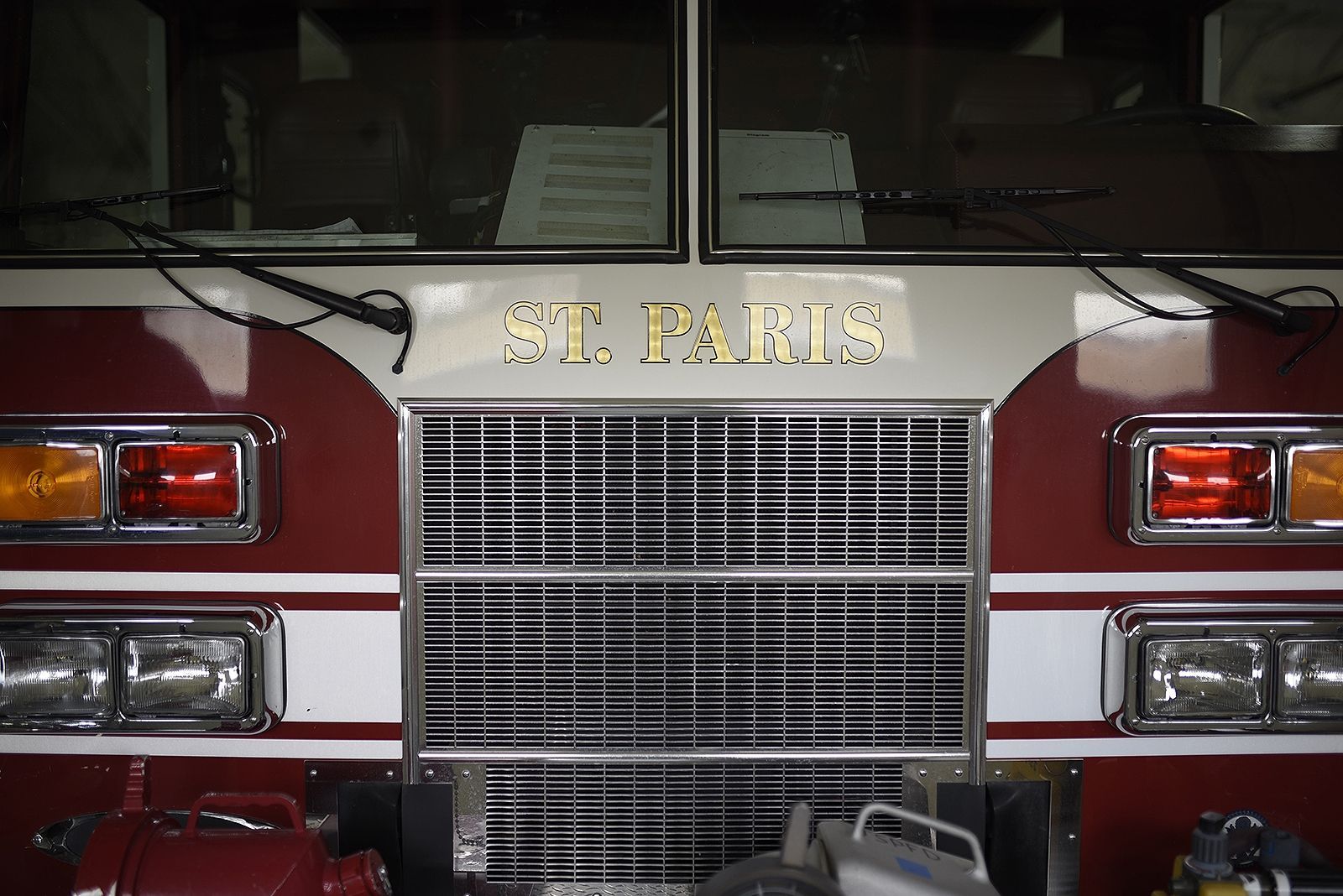 Front view of a red and white St. Paris fire truck, showing the grille and lights.