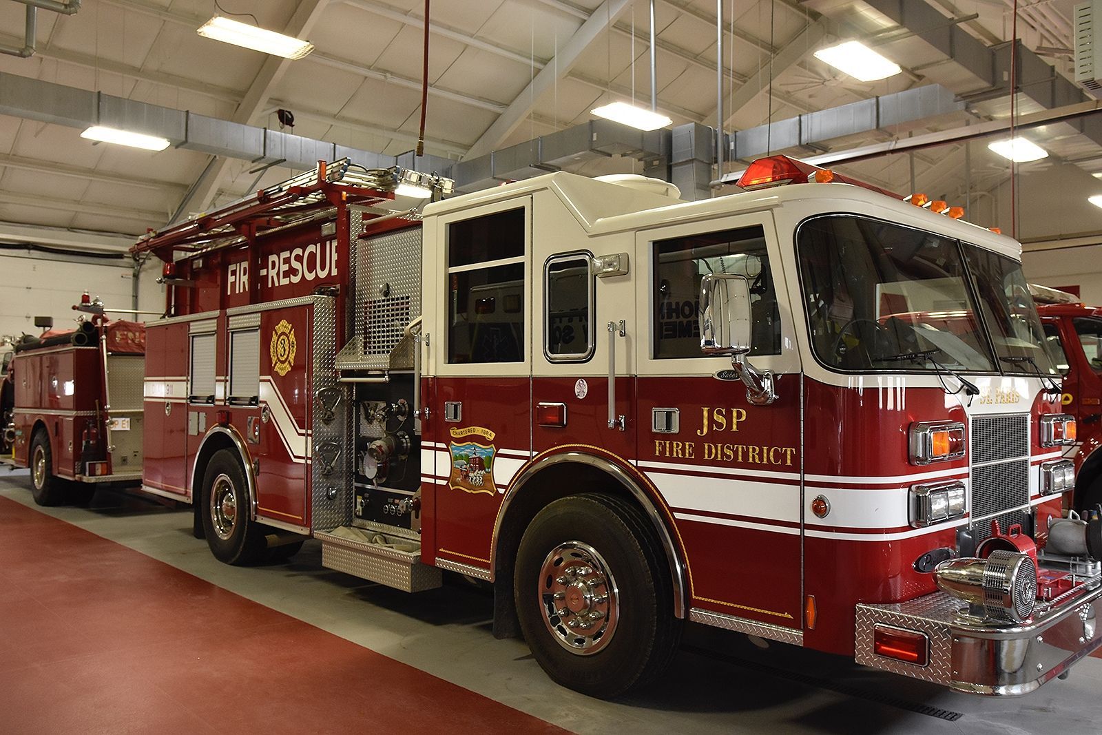 Fire truck parked inside a garage. Red and white with