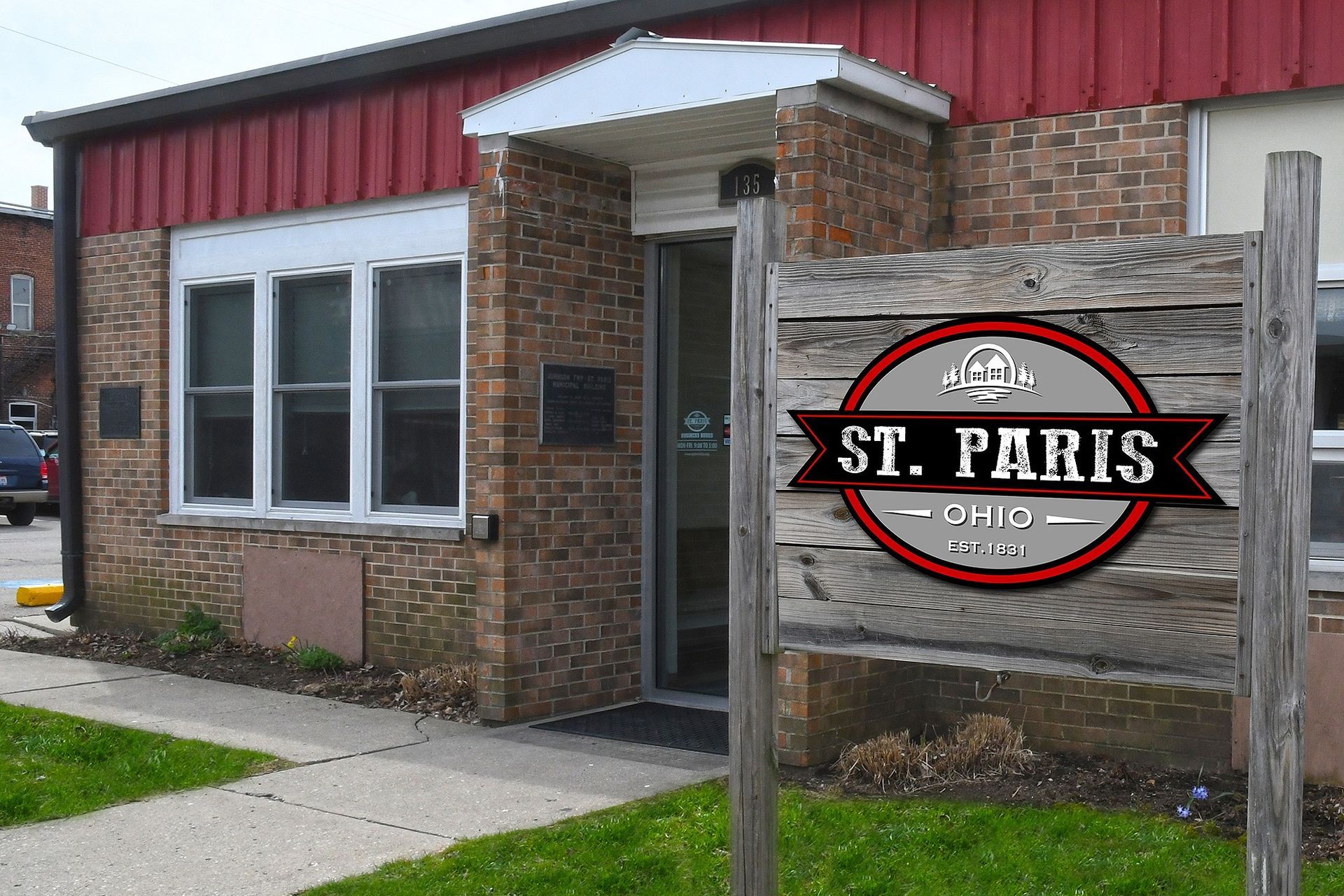St. Paris Clinic building with a wooden sign in front.