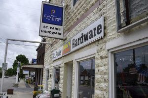 St. Paris Hardware store exterior with sign and windows. Stone building on a town street.