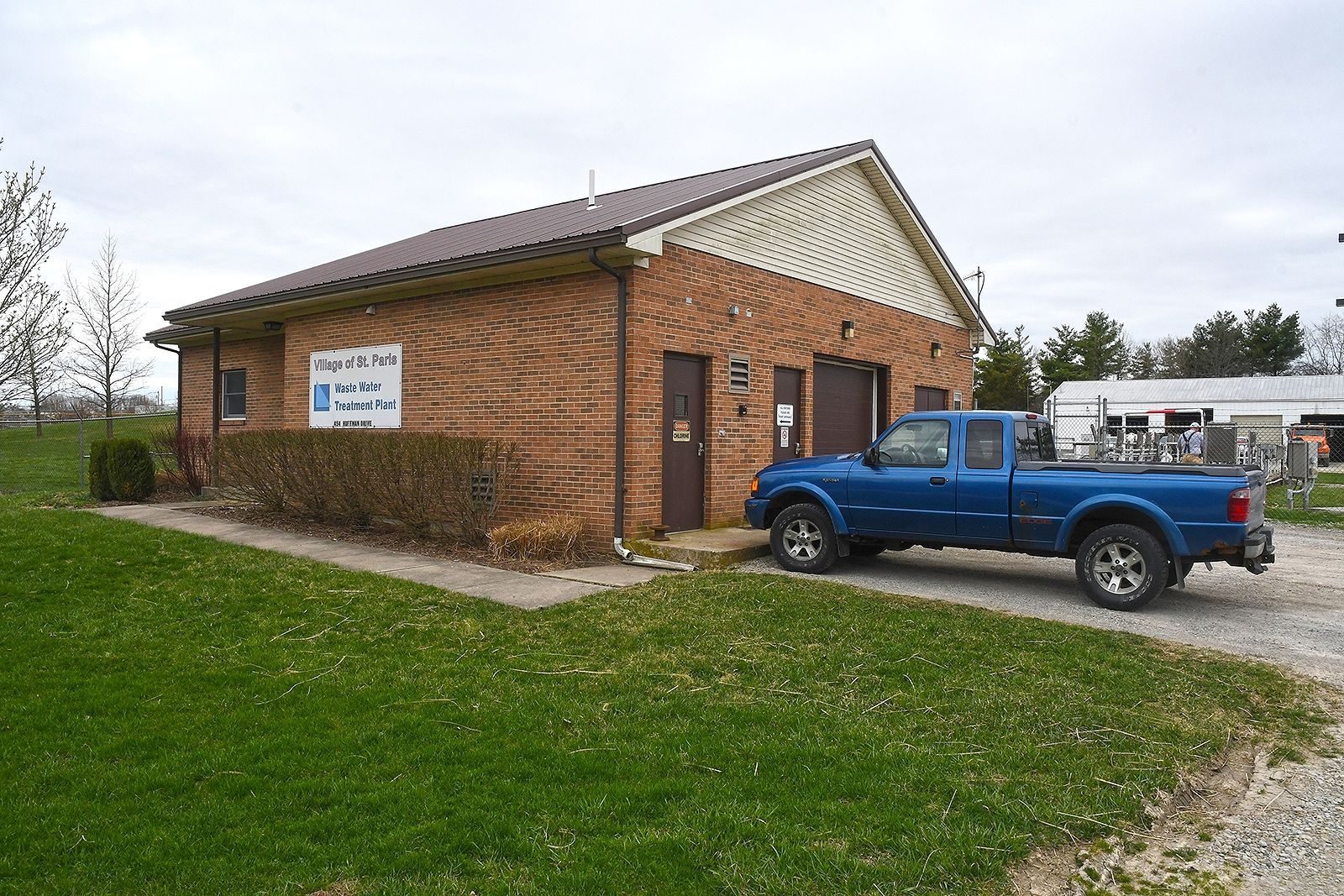 Brick building with a blue truck parked out front; grassy lawn. "Willow Creek Printing" sign visible.