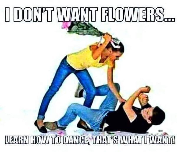 A woman is holding a bouquet of flowers over a man 's head.