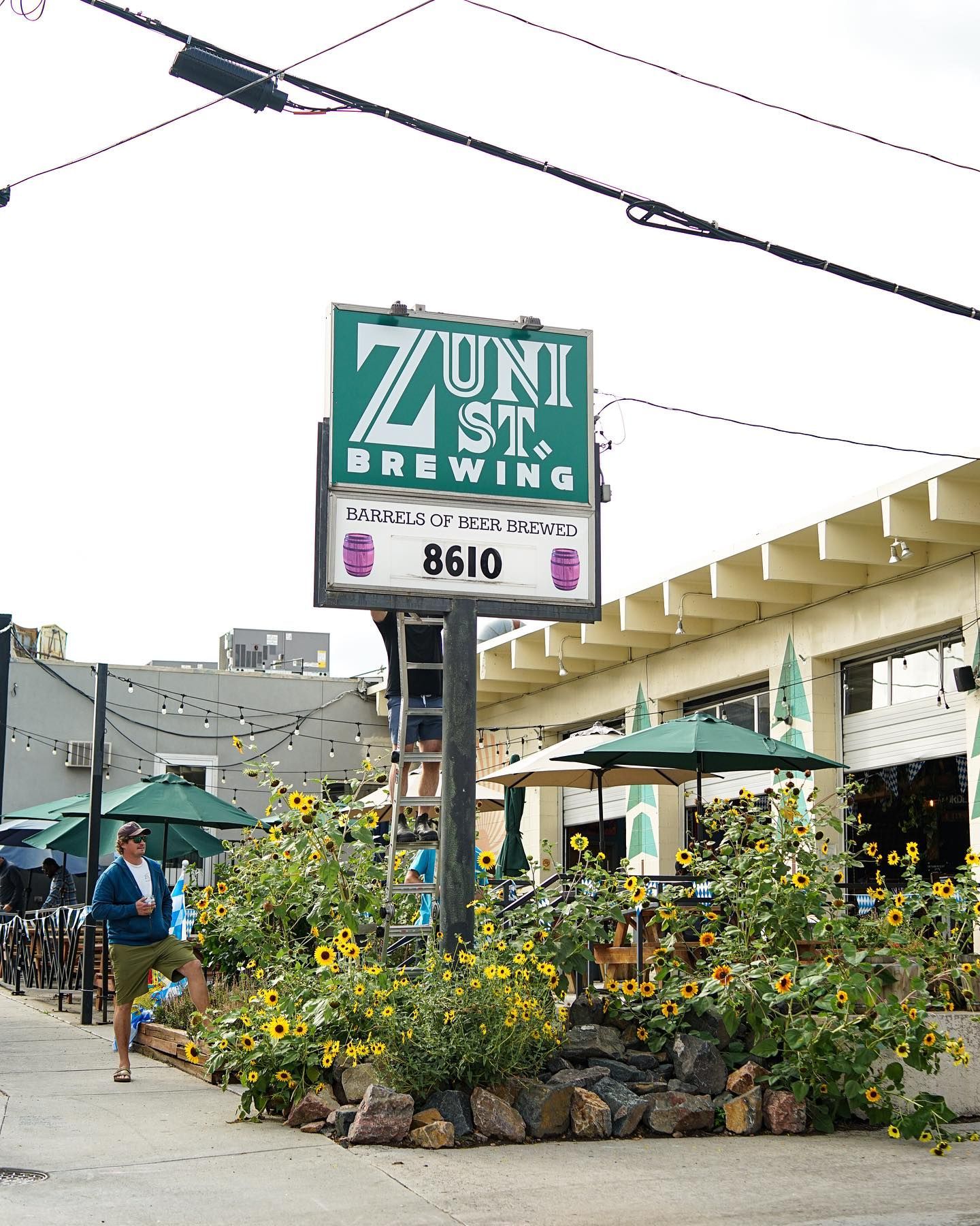 A green and white sign for zuni st. brewing