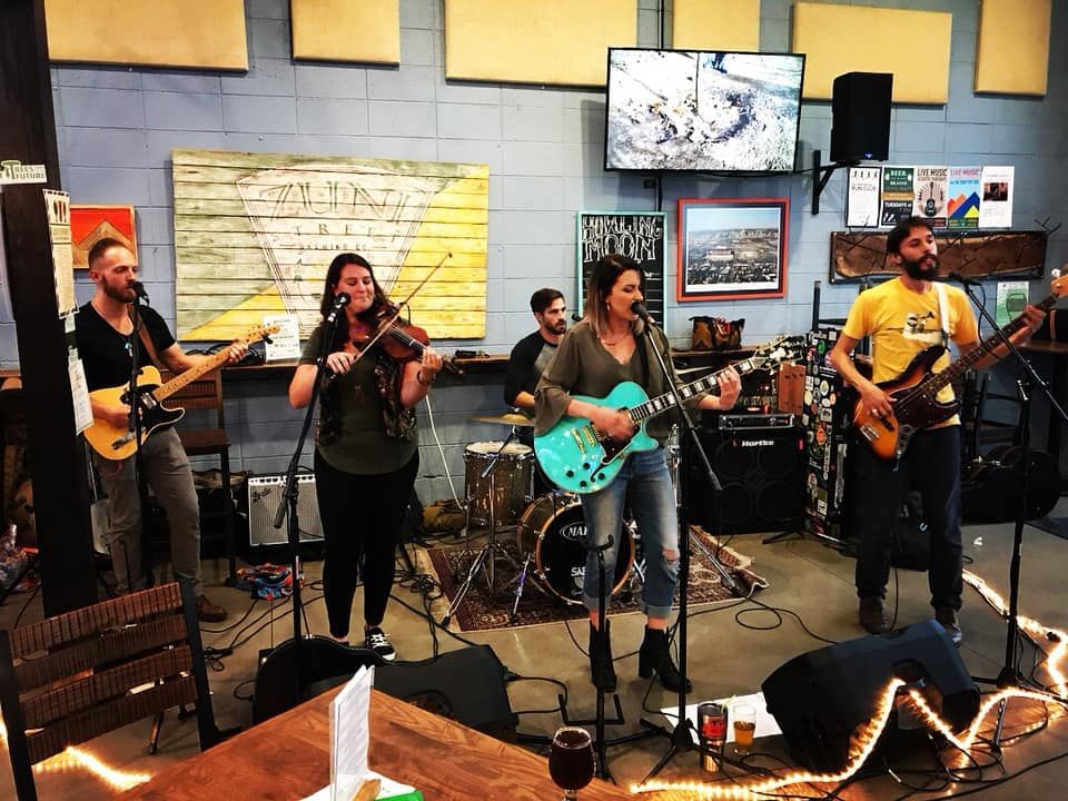 a group of people playing instruments in front of a sign that says alpine