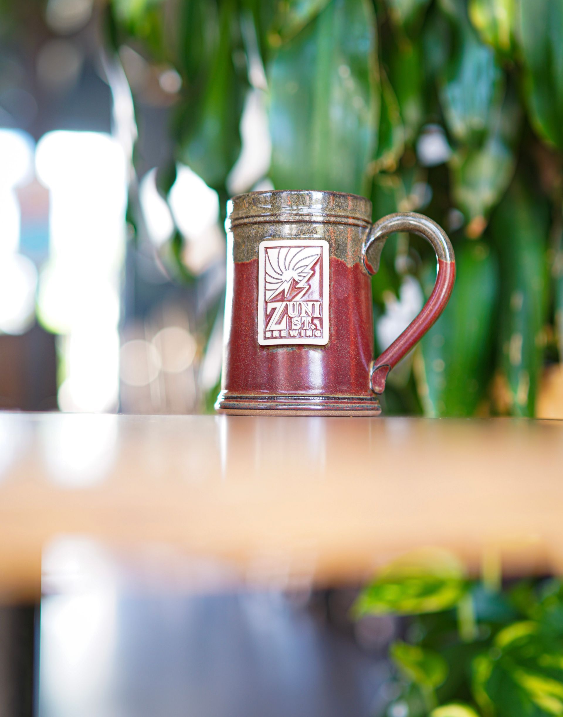 A red mug is sitting on a wooden table.