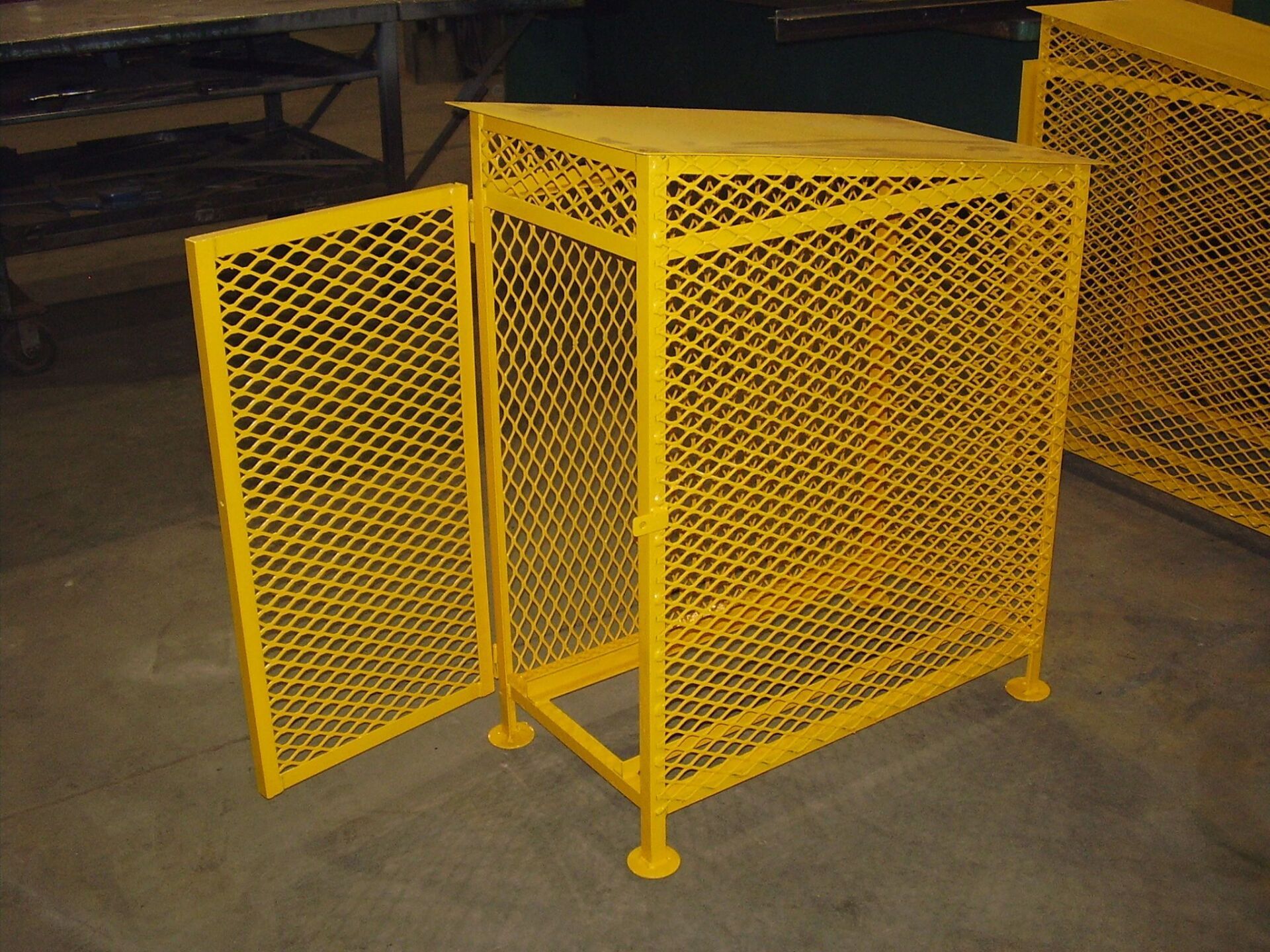 Cage de rangement en métal jaune avec porte ouverte.