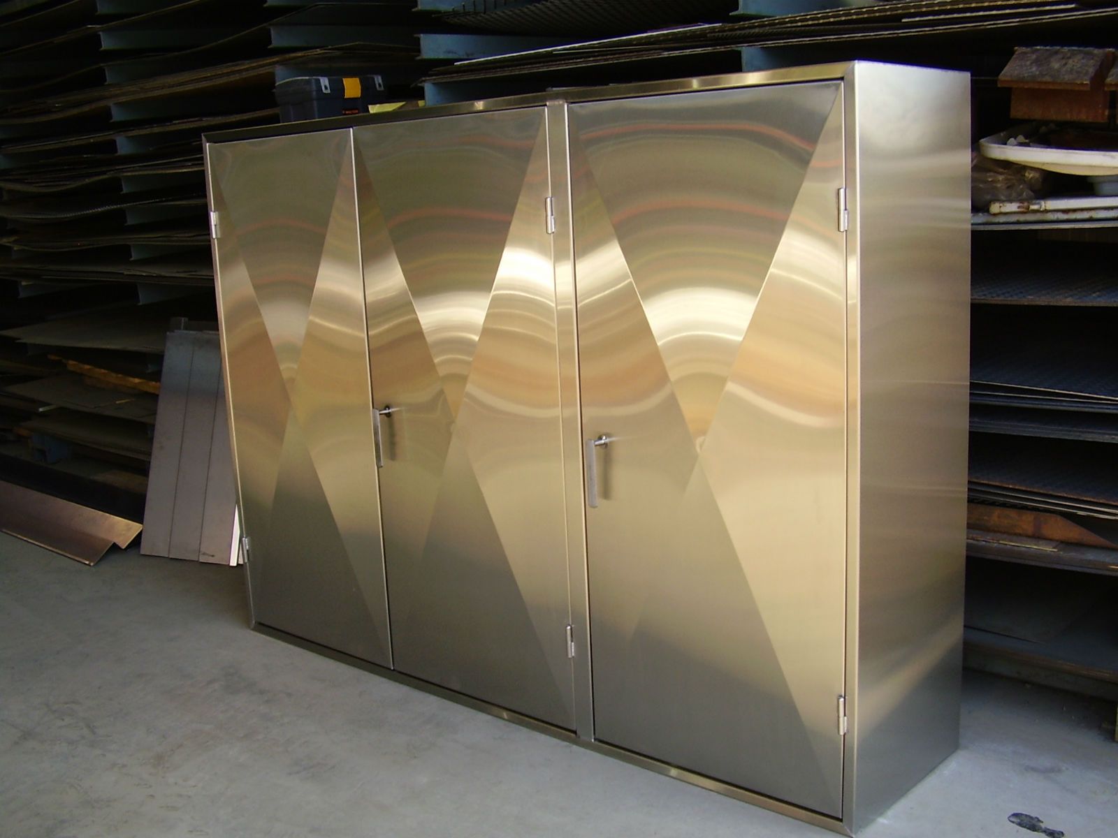 Armoires en acier inoxydable au design angulaire dans un environnement d'atelier.