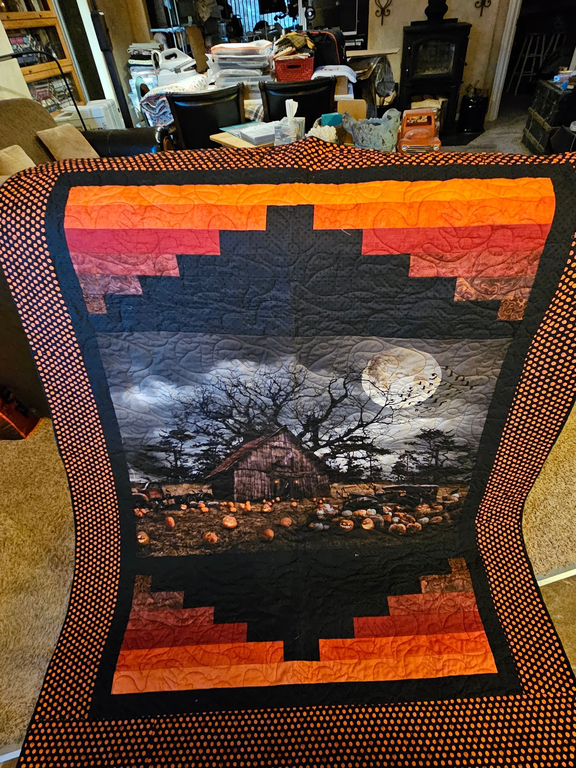 Colorful quilt with a moonlit landscape and silhouetted tree in the center