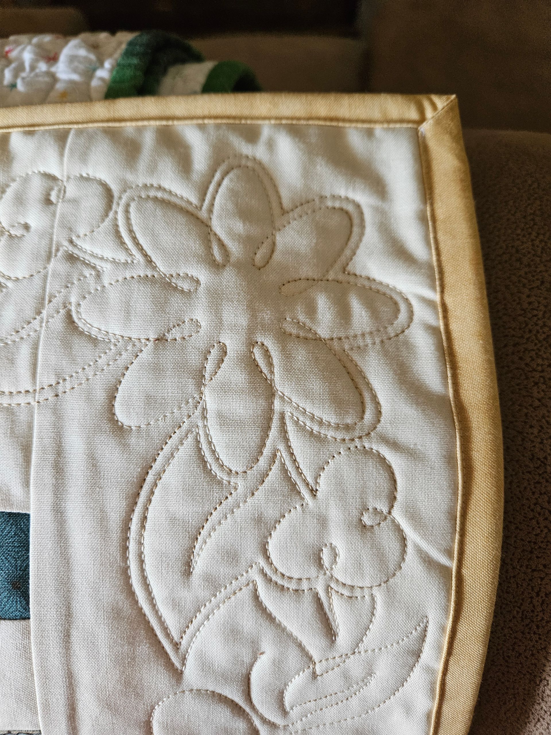 White quilted floral fabric with raised embroidery and beige trim