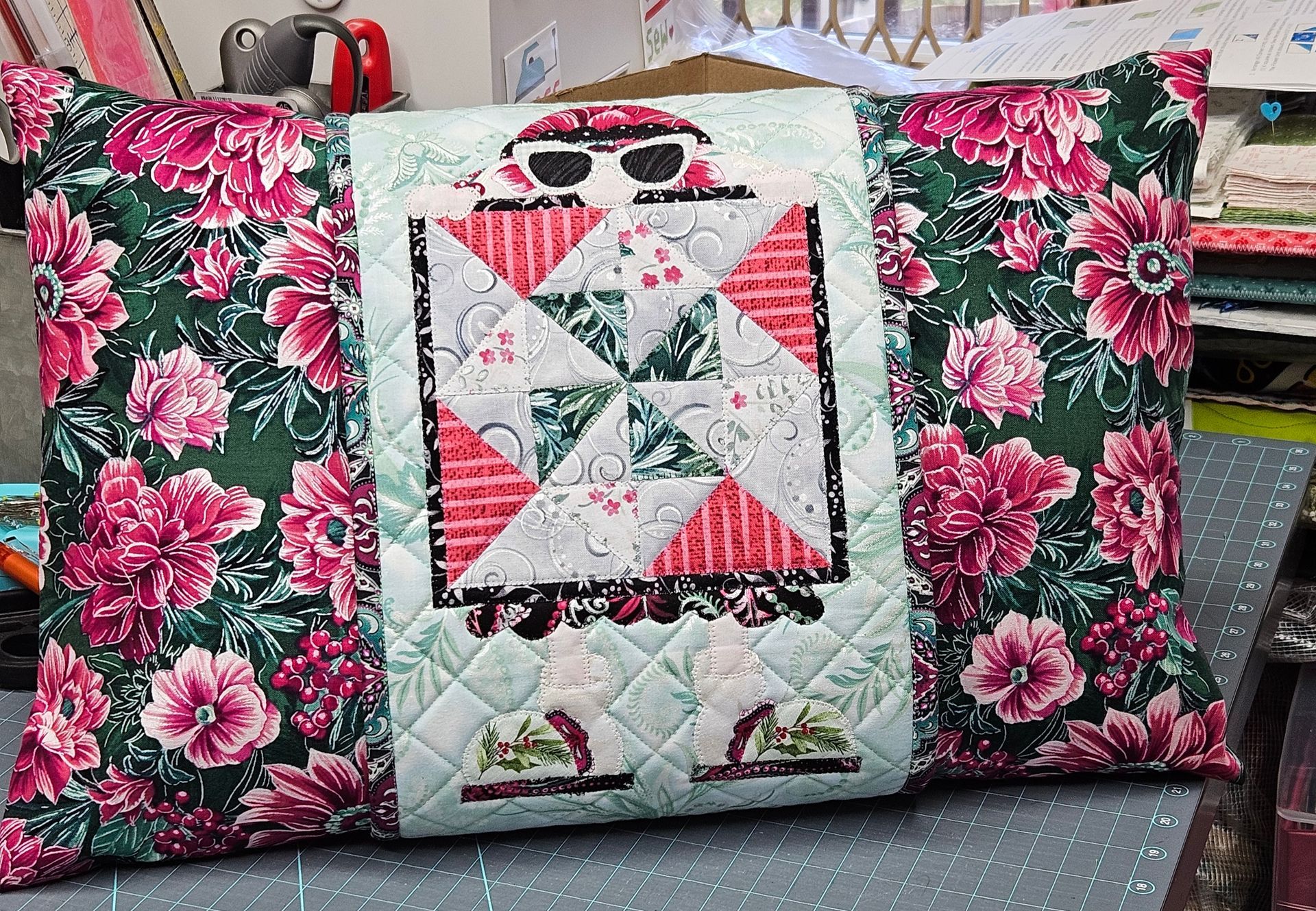 Floral pink cushion with a quilted patchwork panel and bird print on a sofa