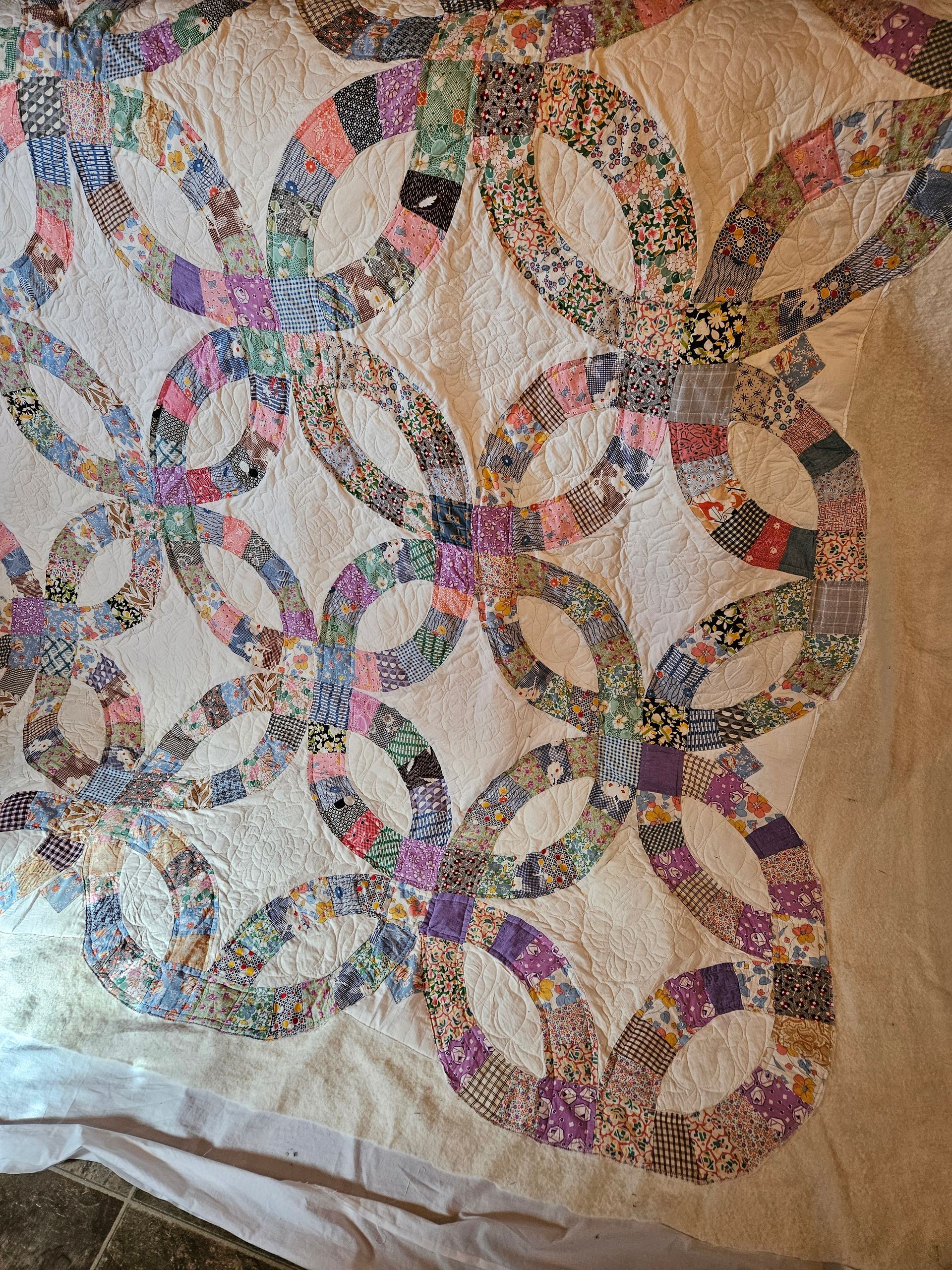 Quilt of interlocking circles in beige, purple, blue, and multicolor patchwork fabric