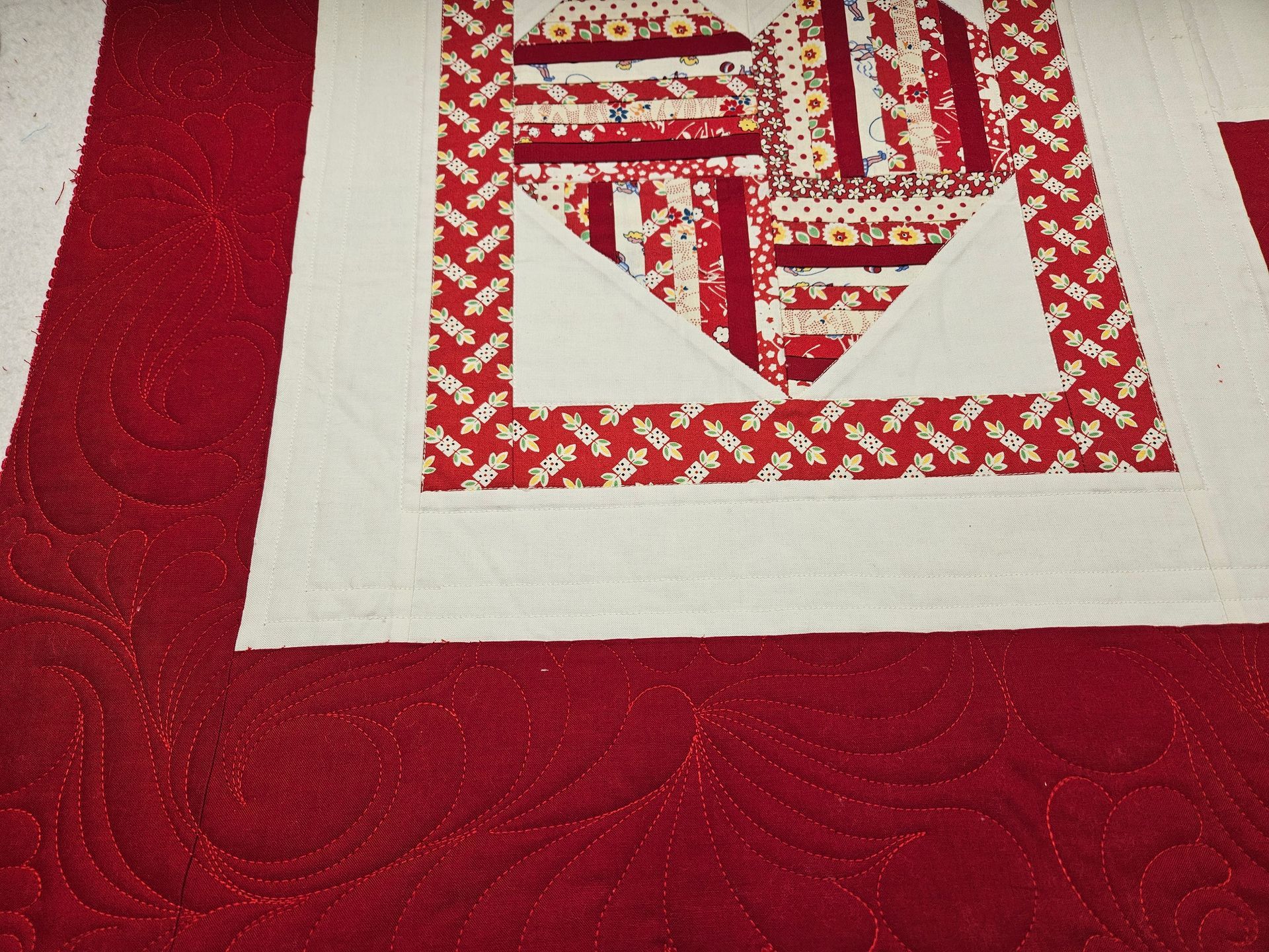 Red and white quilt square on a textured red fabric background