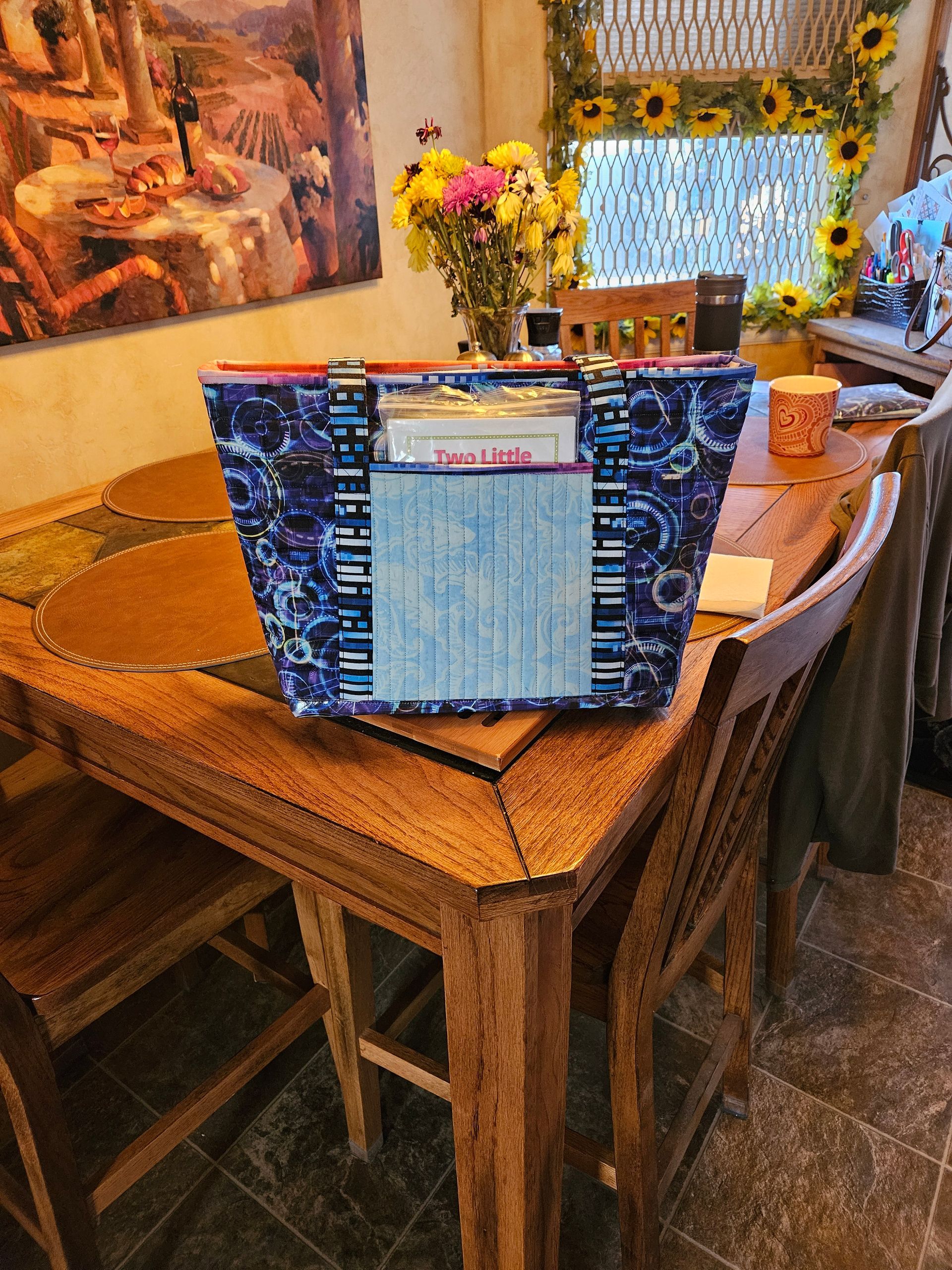 Restaurant table with a blue patterned menu holder and flowers in a cozy dining room.