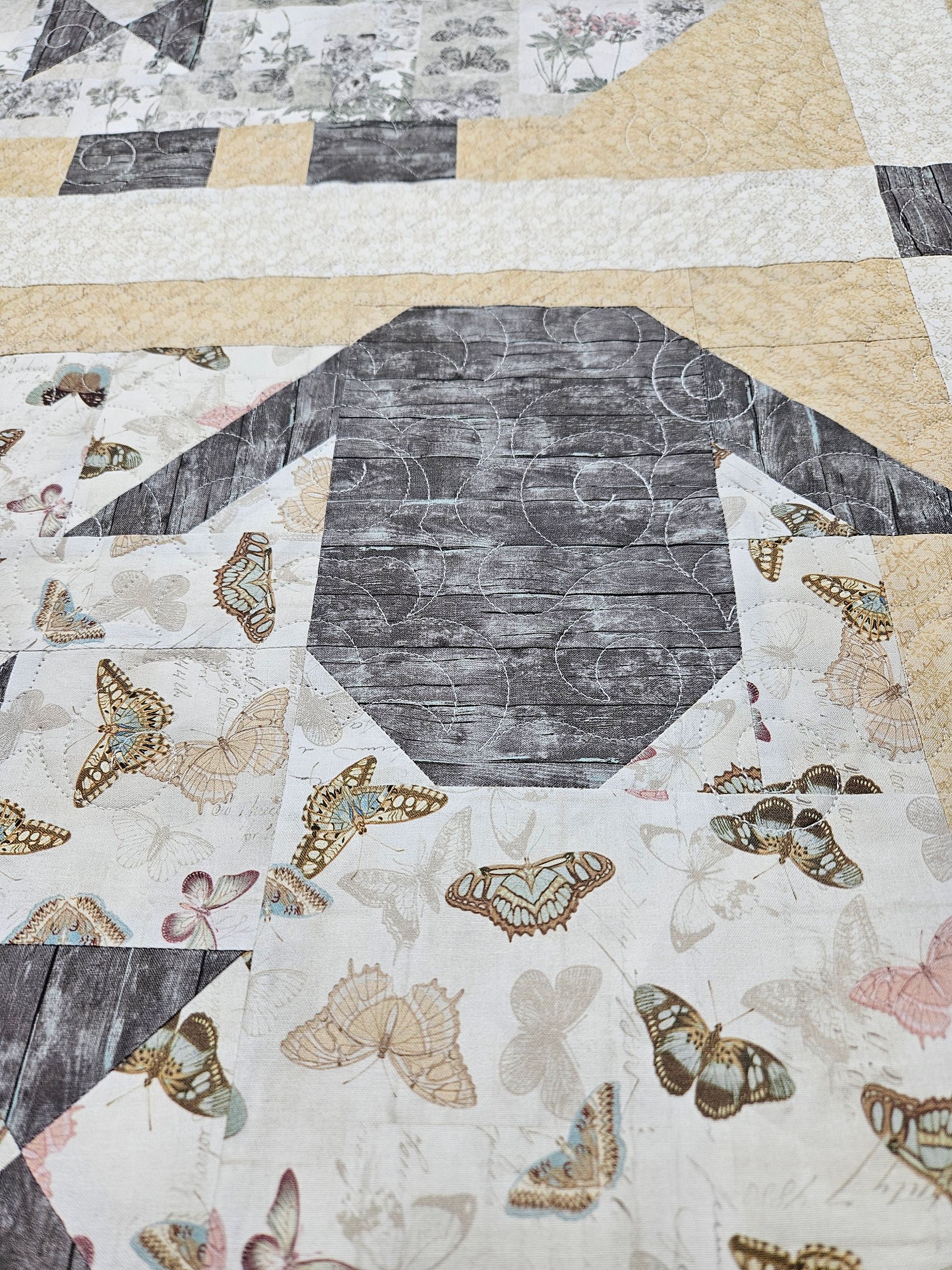 Penguin-shaped floor mosaic in black, white, and beige with scattered butterfly patterns