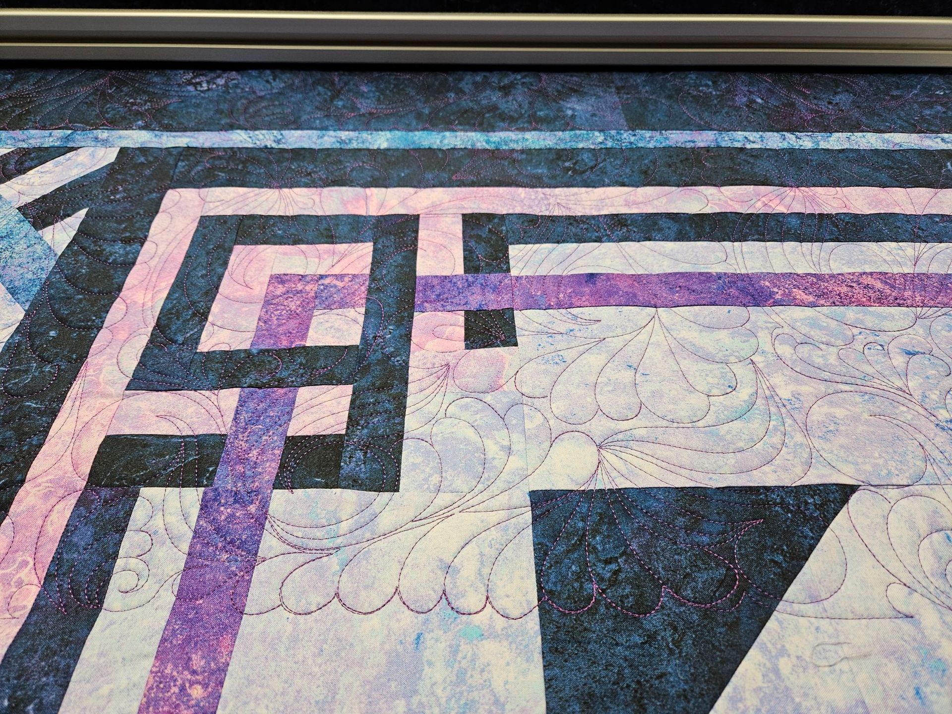 Abstract geometric mosaic with pink, purple, black, and white patterns on a tiled surface