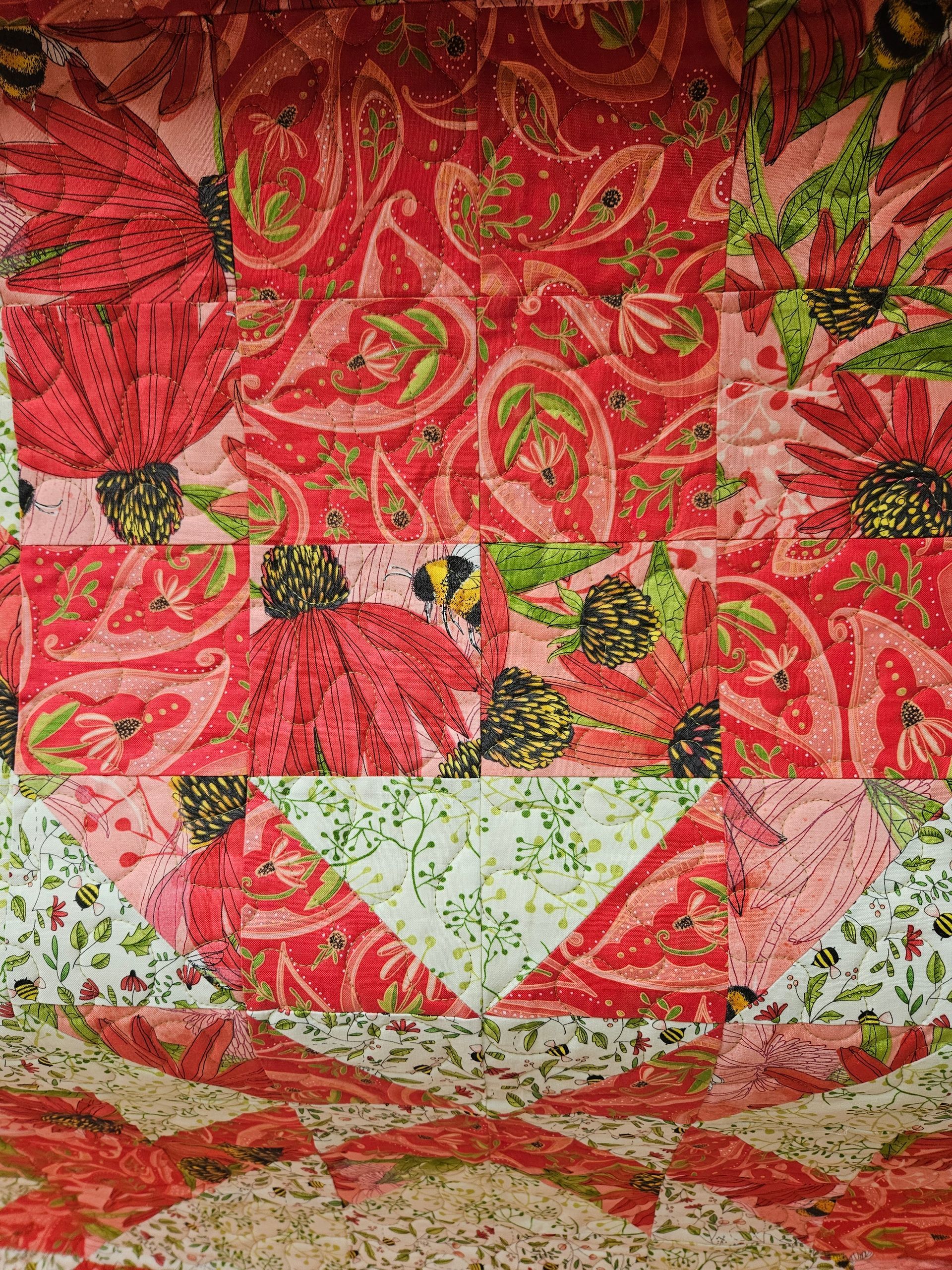 Red floral quilt with pink and green patchwork patterns