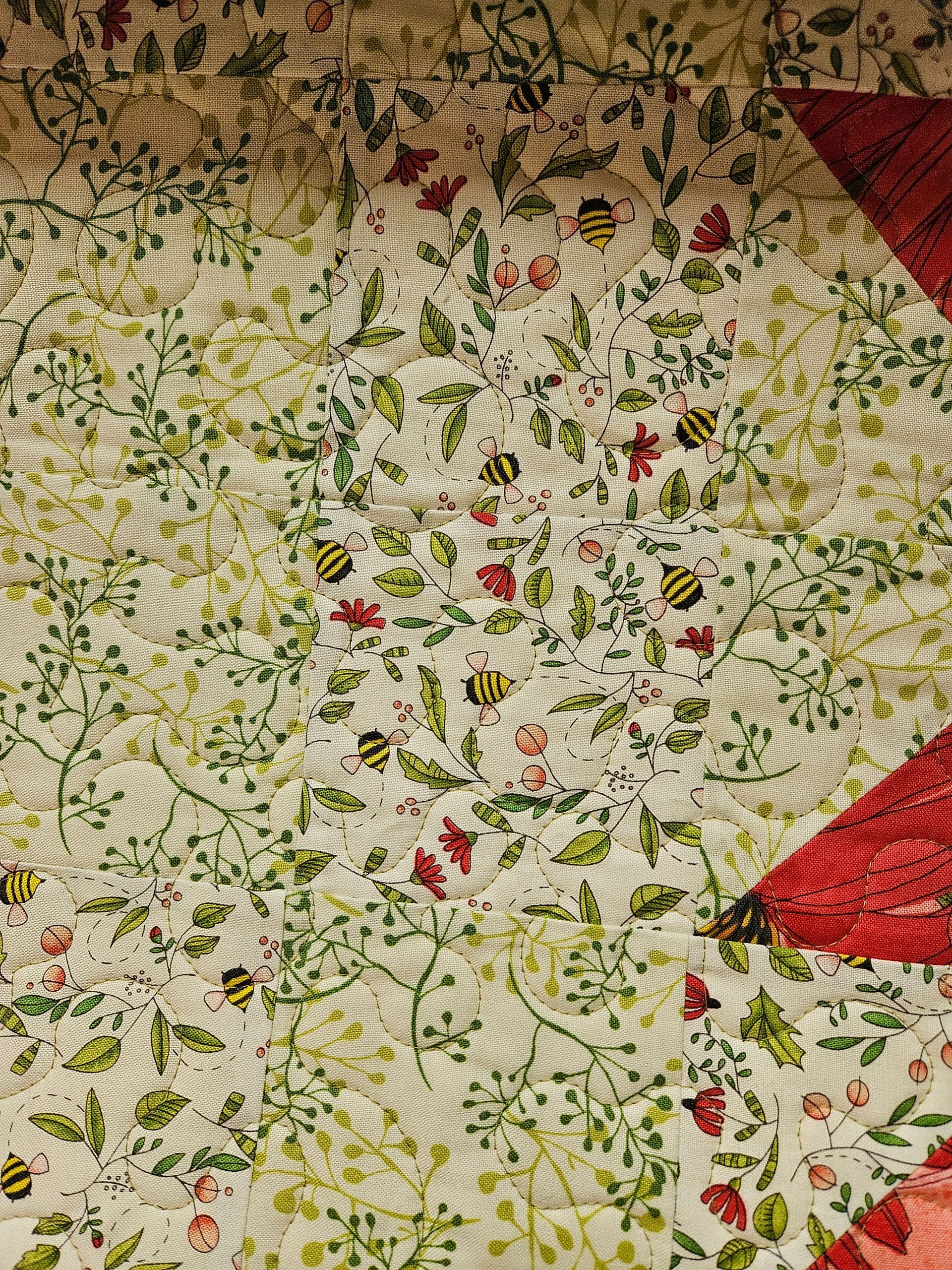 Floral quilt with white background, green stems, red flowers, and red triangular corners