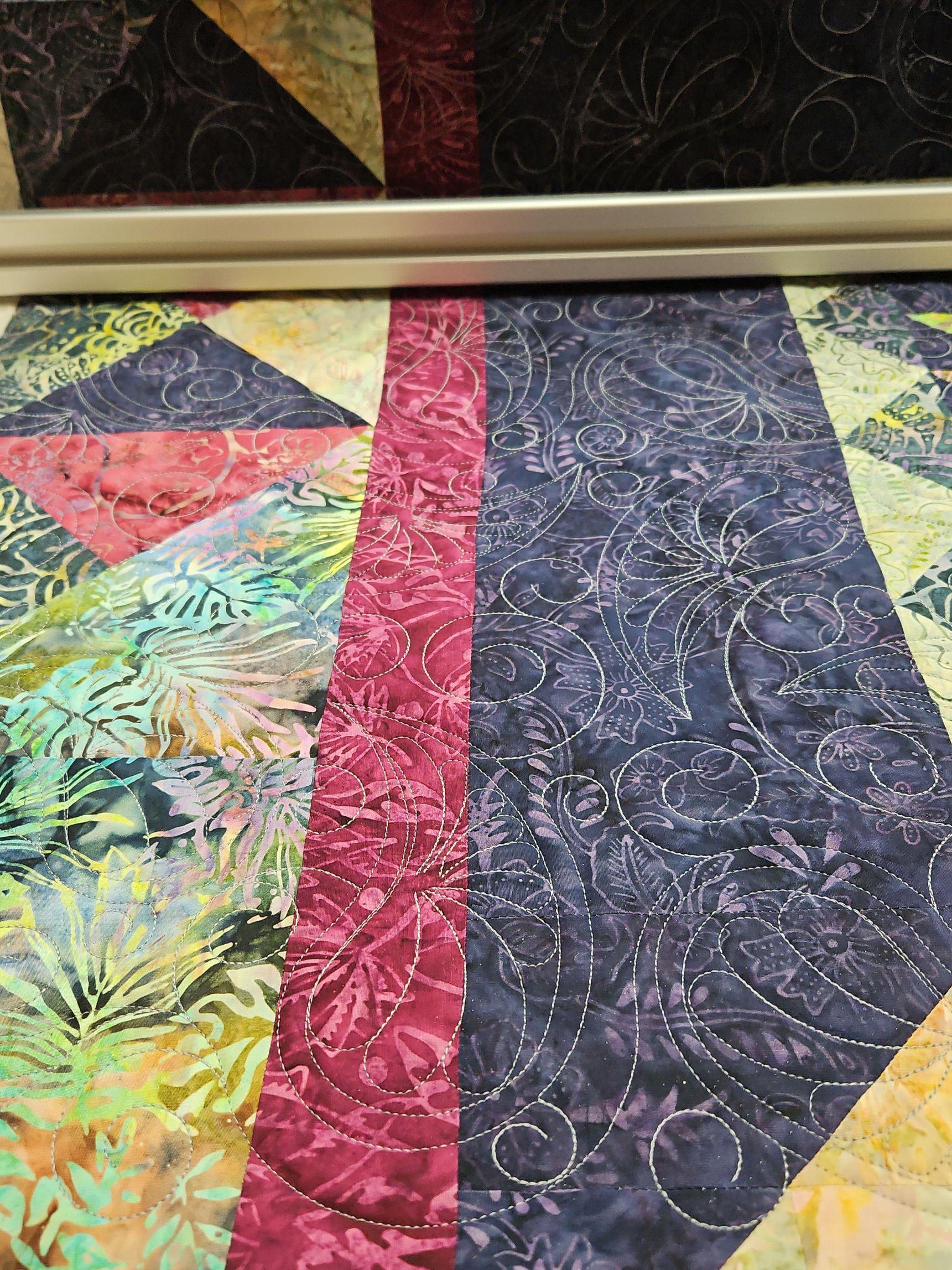 Colorful quilt with geometric fabric panels in red, blue, yellow, and green