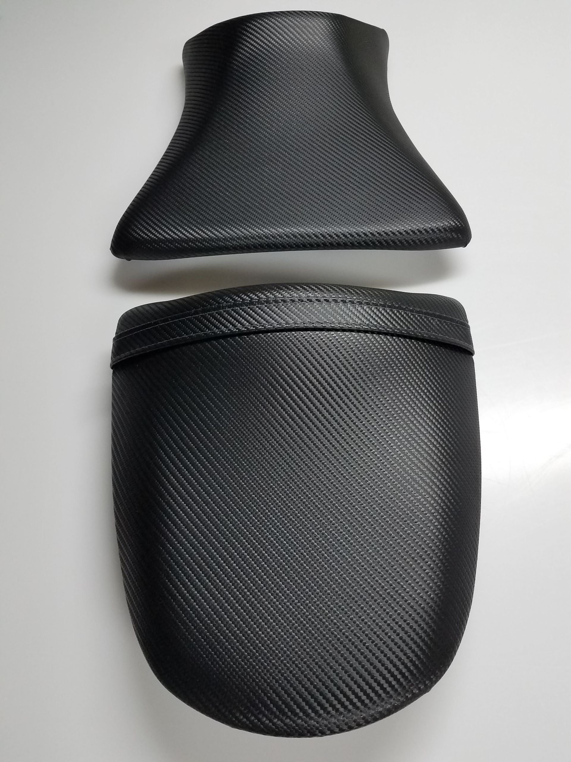 Black textured car headrest pillow with matching storage pouch on a light background
