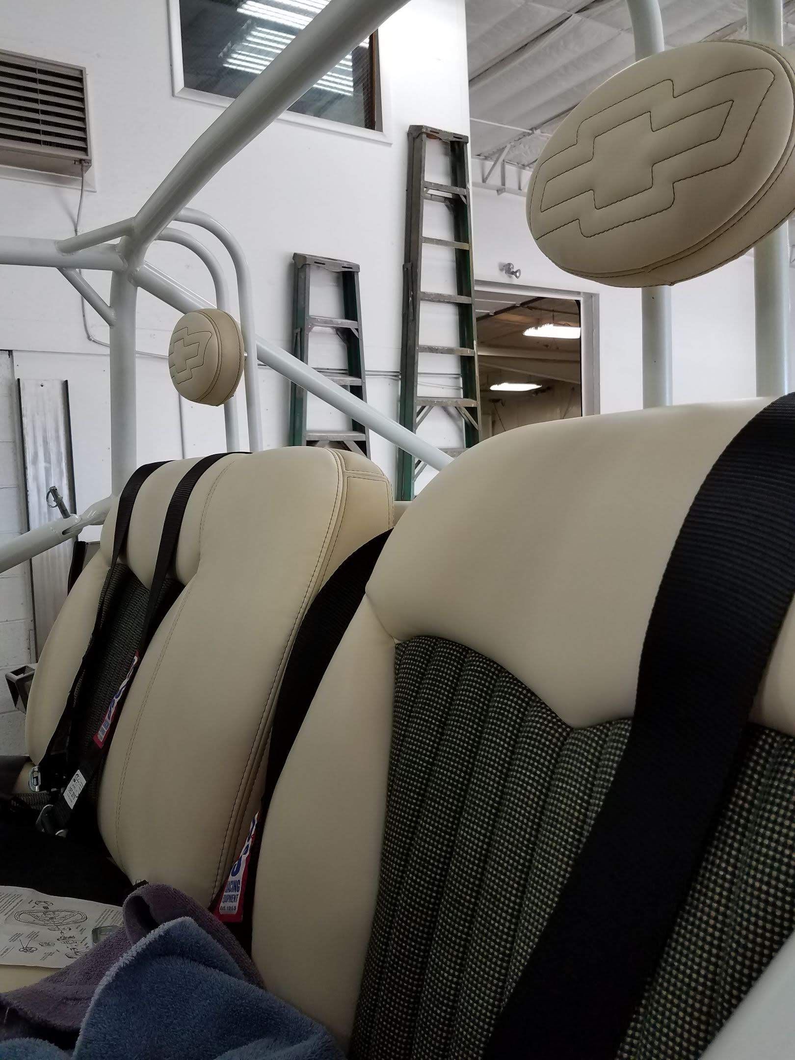 Bus interior with beige and black seats and overhead hand straps