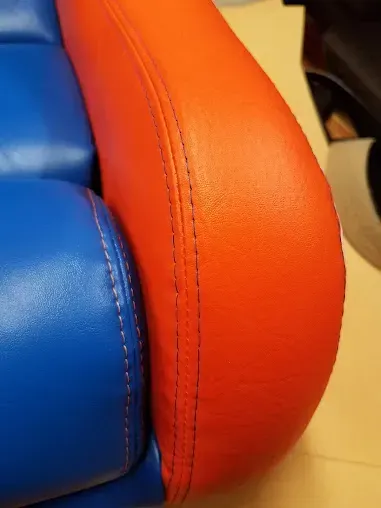 Close-up of a blue and orange upholstered chair seam and cushion edge