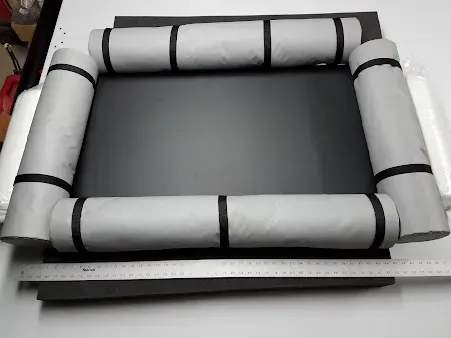 White foam-padded rectangular frame surrounding a dark gray center on a tabletop