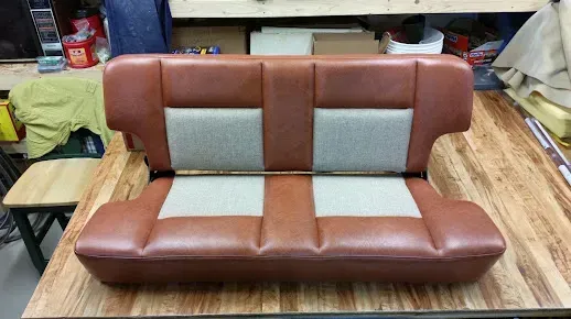 Brown and gray upholstered sofa on a wooden table in a workshop