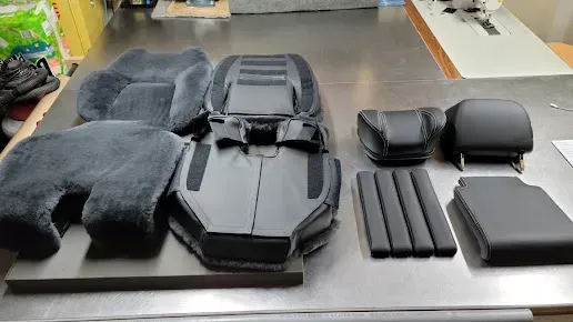 Black molded cases and pouches arranged on a workbench, likely protective gear or storage containers.