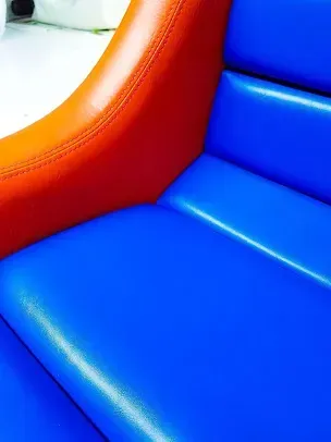 Close-up of a colorful inflatable play structure with blue and orange vinyl seats.
