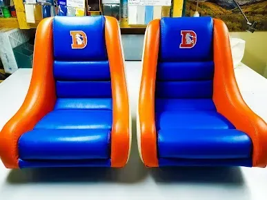 Two blue-and-orange inflatable chair seats with letter D backs on a table