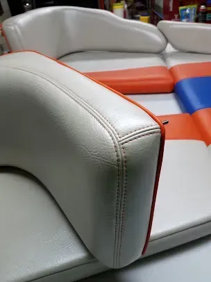 Close-up of a white and orange padded play structure with stitched seams and blue accents