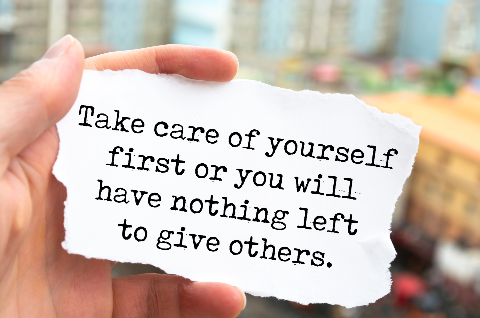 Hand holding torn paper with text: 