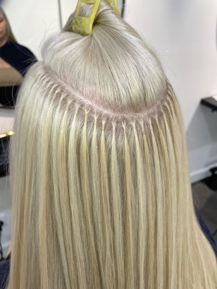 Der Hinterkopf einer Frau mit blonden Haarverlängerungen.