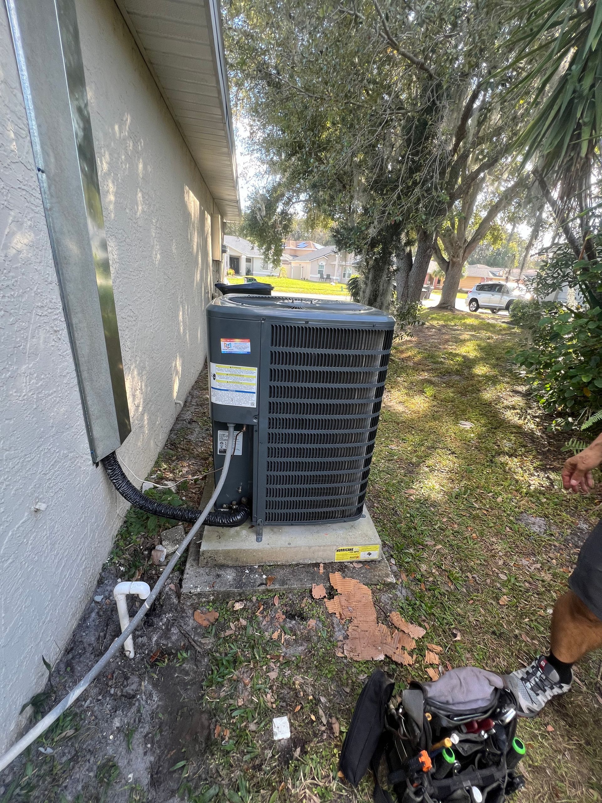 a man is working on an air conditioner outside of a house .