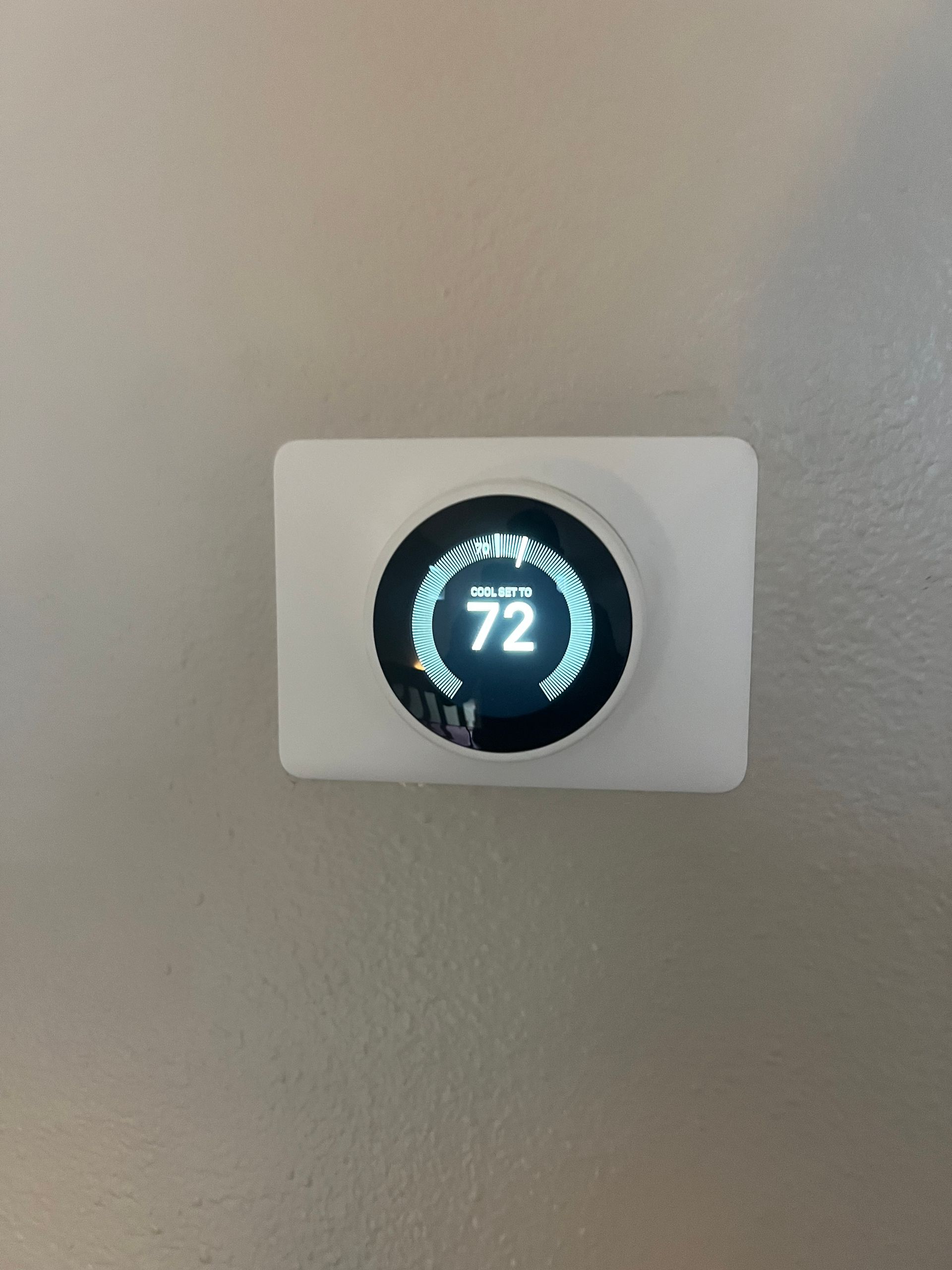 a white thermostat with the number 72 on it