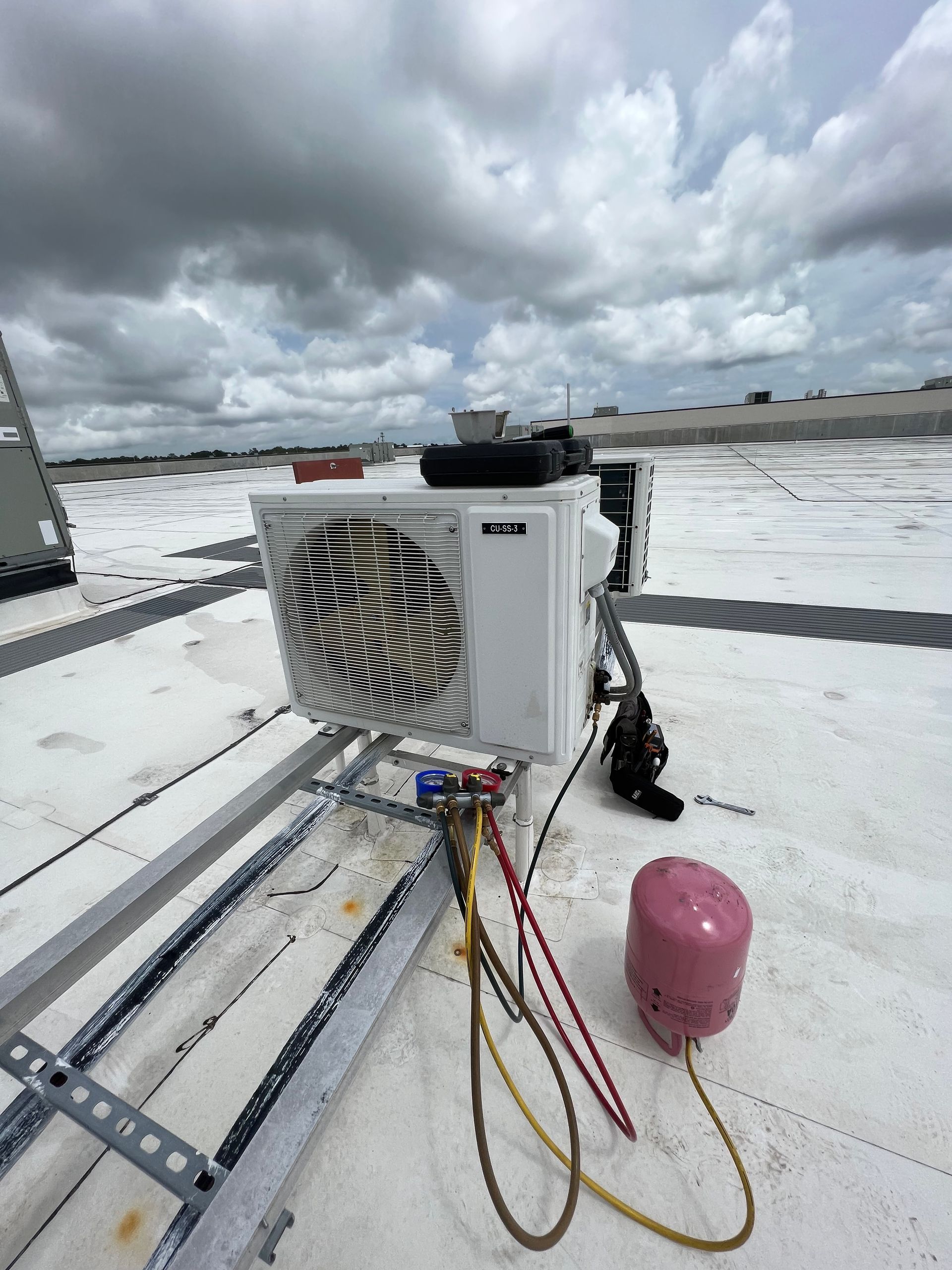 a white air conditioner is sitting on top of a white roof .