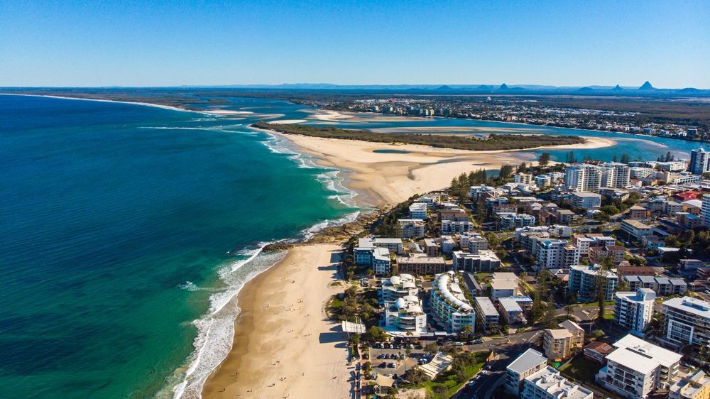 An Aerial View Of A Beach With A City In The Background — Reynolds Built In Kings Beach, QLD
