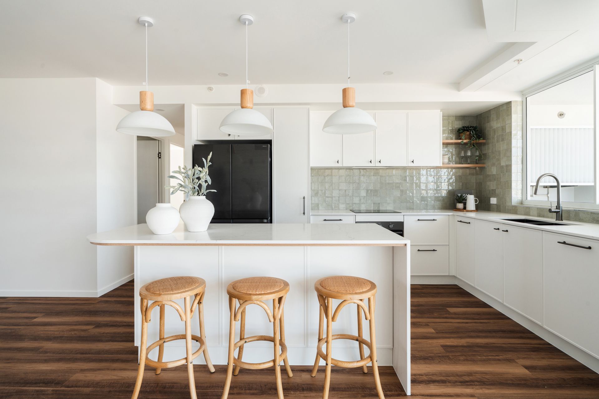 A Bright, Modern Kitchen Featuring a White Island With Three Rattan Stools — Reynolds Built In Caloundra, QLD