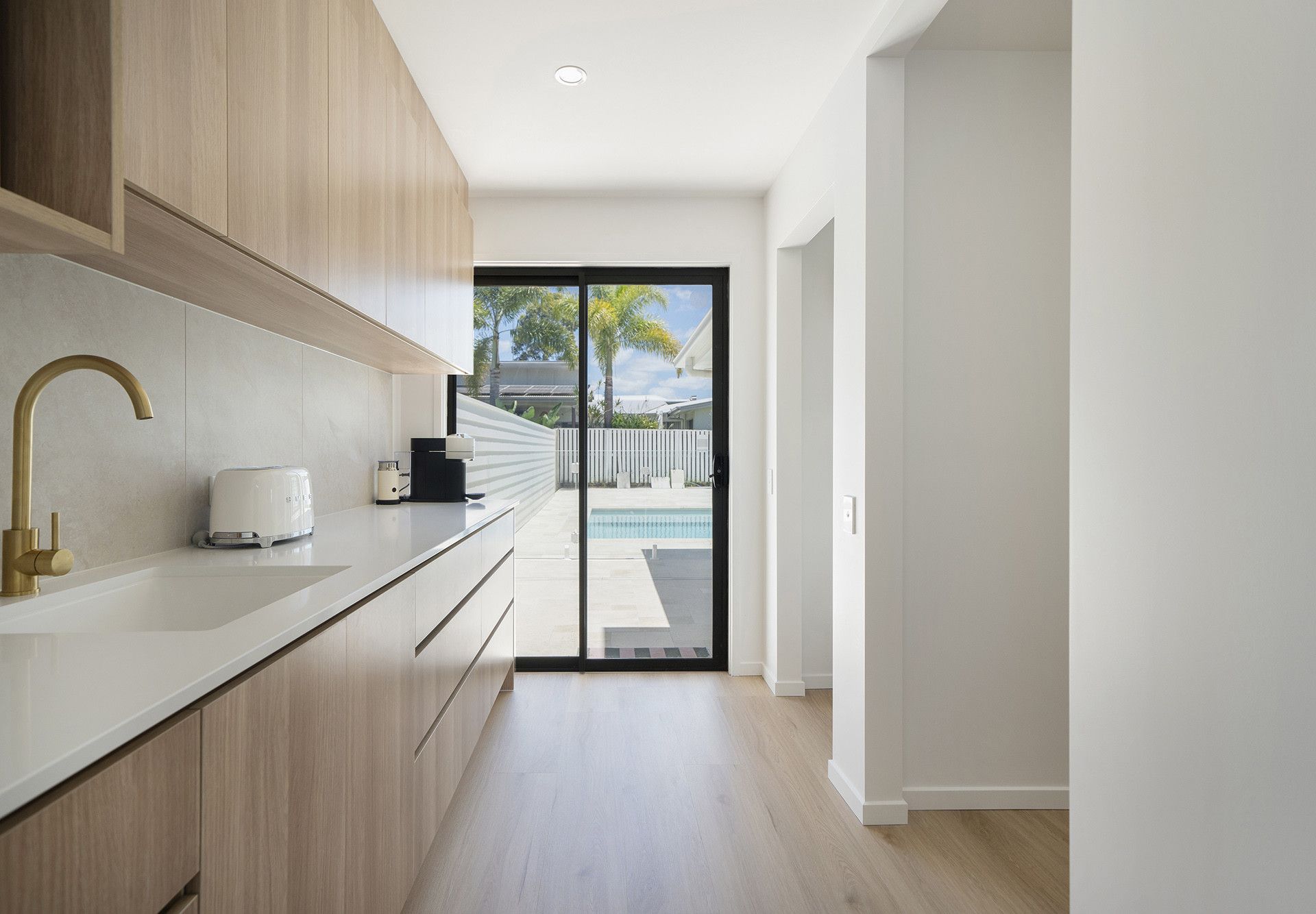 Modern Galley Kitchen With Light Wood Cabinets, White Counters — Reynolds Built In Caloundra, QLD